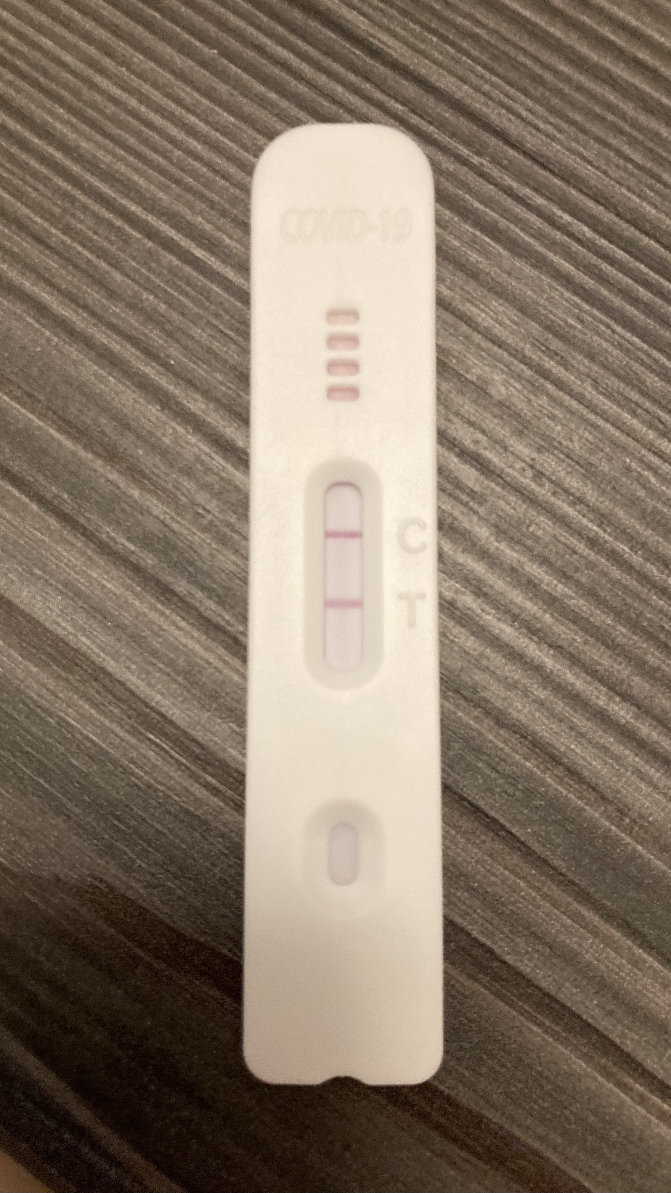 picture of a corona rapid antigen test with lines at test and control, indicating a positive result